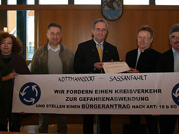 Einen von 120 Ortsbewohnern unterschriebenen Bürgerantrag auf Errichtung eines Kreisverkehrs bei Köttmannsdorf nahm Hirschaids Bürgermeister Andreas Schlund (Mitte) entgegen.  Foto: Werner Baier