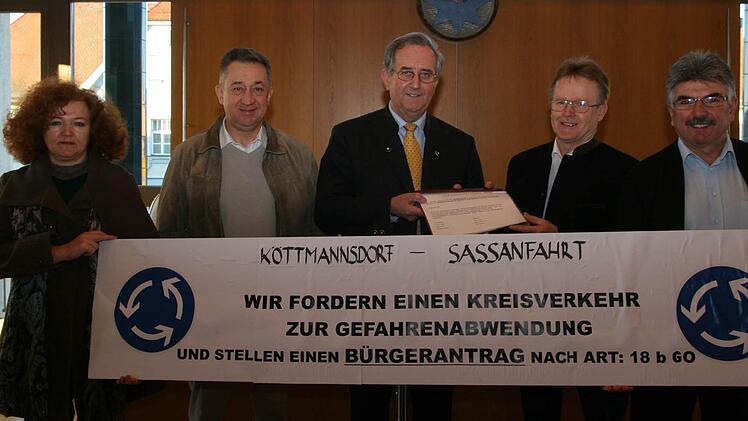 Einen von 120 Ortsbewohnern unterschriebenen Bürgerantrag auf Errichtung eines Kreisverkehrs bei Köttmannsdorf nahm Hirschaids Bürgermeister Andreas Schlund (Mitte) entgegen.  Foto: Werner Baier