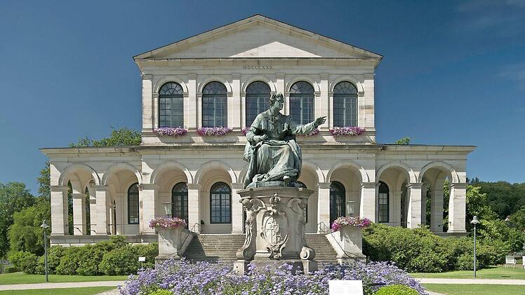 Die edle Anlage des Staatsbades durchquert der Wanderer. Im Vordergrund die Statue von König Ludwig I.