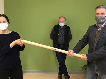 Ulrike Schade (Th&uuml;ringer Verwaltung UNESCO-Biosph&auml;renreservat Rh&ouml;n) hat die Federf&uuml;hrung von Torsten Raab (Hessische Verwaltung) &uuml;bernommen. F&uuml;r die symbolische &Uuml;bergabe haben die Mitarbeiter des Naturparks Hessische Rh&ouml;n eigens einen neuen Coronakonformen Staffelstab angefertigt. Auch der Bayerische Verwaltungsstellenleiter Michael Geier (Mitte) freut sich auf die weitere l&auml;nder&uuml;bergreifende Zusammenarbeit. Foto: Anna-Lena Bieneck