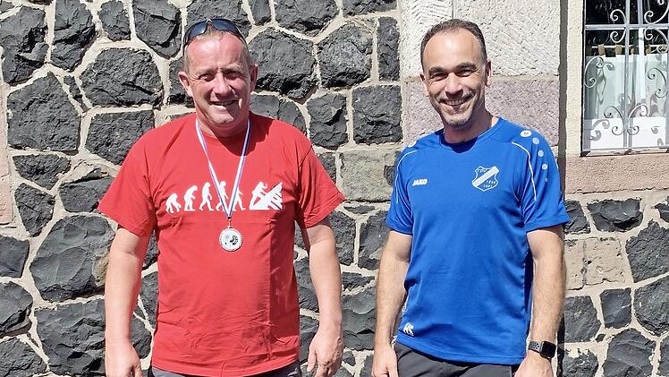 F&uuml;r zehnmalige Teilnahme an der Kreuzbergwanderung wurde Martin Metz (links) vom 1. Vorsitzenden des TSV Arnshausen, Holger Schmitt, mit einer Medaille geehrt.