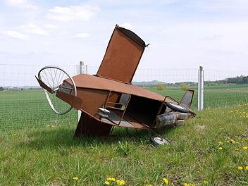 Ein Modell, das Flugplatzgegner gebaut haben liegt auf einer Wiese nahe dem Gelände, auf dem der neue Verkehrslandeplatz gebaut werden soll. Foto: Berthold Köhler
