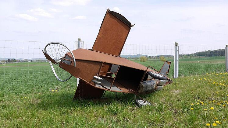 Ein Modell, das Flugplatzgegner gebaut haben liegt auf einer Wiese nahe dem Gelände, auf dem der neue Verkehrslandeplatz gebaut werden soll. Foto: Berthold Köhler