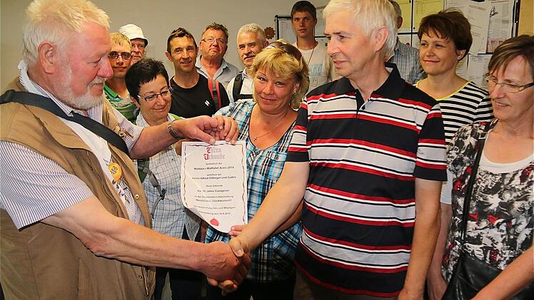 Für die Gastfreundschaft der Caritas-Sozialstation überreicht Wallfahrer Joseph Diegelmann (links) eine Urkunde an Alfred Dillinger.