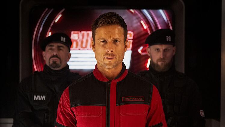 Aktuell im Kino: "Running Man". Der verzweifelte Ben Richards (Glen Powell, Mitte) stellt sich dem Spiel um Leben und Tod.
