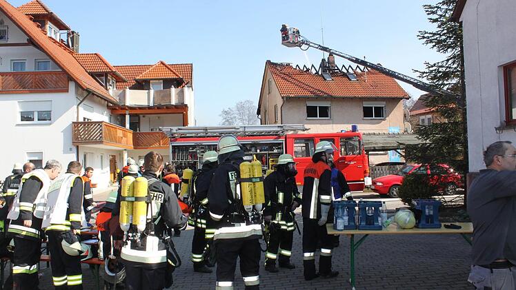 Einsatzkräfte stimmen sich in der Mittelgrundstraße ab, während weitere im und am Haus Löscharbeiten durchführen. Fotos: Anette Schreiber