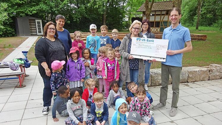Dirigent Stefan Ammersbach (rechts) bei der Scheckübergabe. Mit der Vorsitzenden des Elternbeirats Natascha Hohmann (3. von rechts) und der Kindergartenleiterin Andrea Hippler (links) freuen sich die Kinder und ihre Betreuerinnen.  Foto: Gaby Kirchner