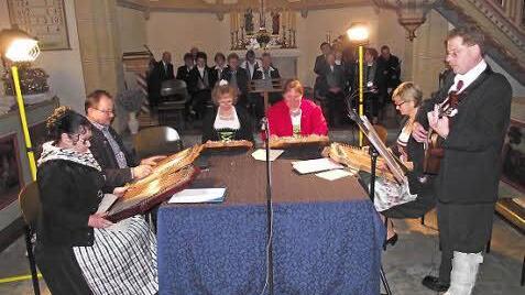Die Akkordzither-Gruppe mit (von links) Veronika Petrat, Heinrich Glaser, Renate Glaser, Christine Winkler, Birgit Haase und Siggi Winkler mit der Gitarre, sowie im Hintergrund der Kirchenchor Küps Foto: Dieter Wolf