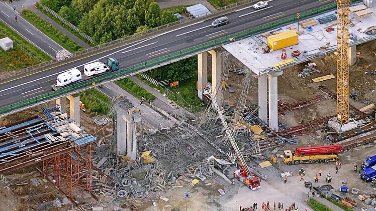 Anwohner aus dem Nachbarort Schraudenbach berichten von einem "Schlag, als sei eine Bombe explodiert": Unmittelbar nach dem Einsturz zeigt das Luftbild von der Unglücksstelle das ganze Ausmaß der Zerstörung, während der Verkehr weiter über die alte Brücke der A7 läuft. Foto: dpa