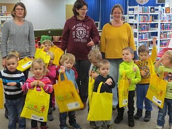 Der Kindergarten Wildflecken war zu Besuch in der Gemeinde-Bibliothek, um die Lesestart-Sets in Empfang zu nehmen. Hinter den Kindern stehen die Leiterin des Kindergartens, Susanne Raab, sowie das Bibliotheksteam Sabine Loeber und Heike Kettemer. Foto: Gemeinde-Bibliothek