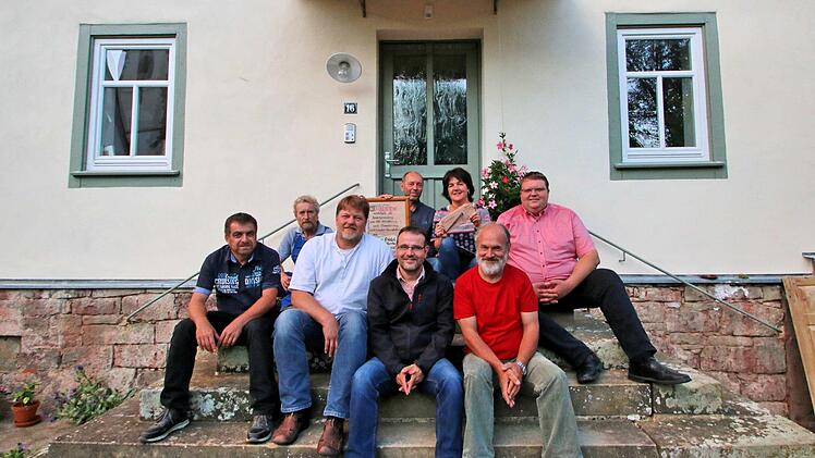 Das frühere Pfarrhaus von Kleinwenkheim wurde von Charlie Friedel und Anja  Heide (hinten, vor der Türe) saniert. Dafür bekamen sie vom Altstadtverein  den "Mürschter Nagel". Vorne auf dem Bild (v.l.) Kassier Wolfgang Joa,  Nachbar Peter Bieberich, Co-Vorsitzender Peter Braun, Co-Vorsitzender Oliver  Schikora, Co-Vorsitzender Josef Wilz und der Dritte Bürgermeister Andreas  Trägner. Foto: Dieter Britz
