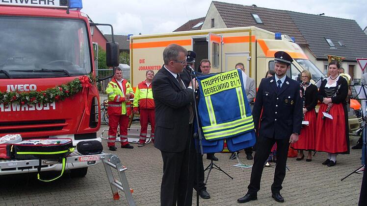 Zur Übergabe des neuen Feuerwehrautos überreichte Bürgermeister Ernst Nickel dem 2. Kommandanten Benedikt Rückel, der sich um die Anschaffung und den Umbau des Autos gekümmert hat, die Truppführerweste. Foto: Nathalie Zapf