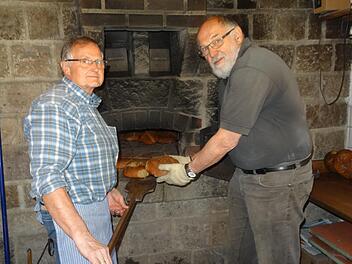 Winfried Bott (links) und Siegfried Wiesner vom Obst- und Gartenbauverein (OGV) Bad Br&uuml;ckenau sch&uuml;rten den Ofen im Backhaus und fertigten den Teig. Foto: Martina Fuchs