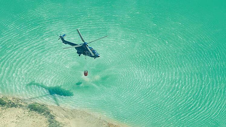 Ein Hubschrauber nimmt Löschwasser auf.  Foto: Tobias Köpplinger