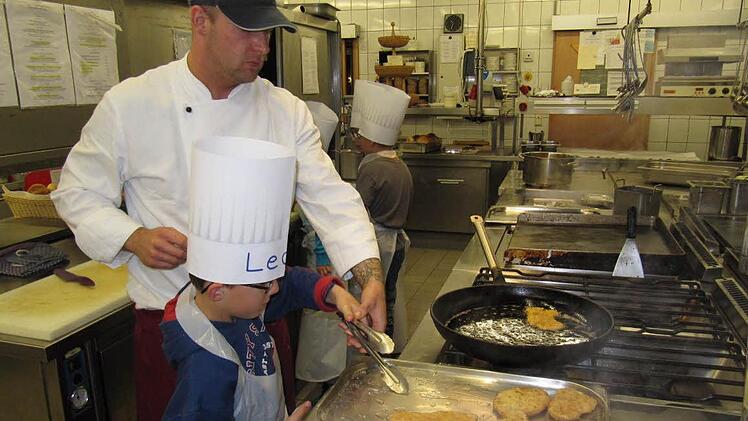 Leon und Koch Christian Popp beim Ausbacken der Schnitzel