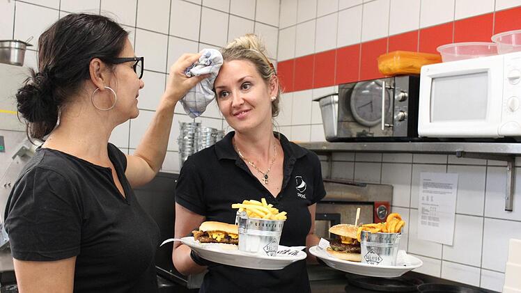 Besonders heiß geht es in diesen Tagen in der Küche des Downtown-Diners in Hammelburg zu. Deshalb tupft Birgit Sada (links) sogar mal Anastasija Jampolski den Schweiß von der Stirn. Foto: Isabel Herterich