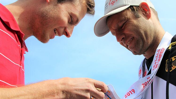 Wohnheimleiter Christoph Deckert, der mit Stefan Weidner auch schon Triathlon trainiert hat, begutachtet fasziniert die beiden Goldmedaillen.