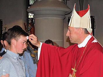 Weihbischof Herwig Gössl spendete in Steinwiesen den Jugendlichen - hier Sebastian Wachter - das Sakrament der Heiligen Firmung. Foto: Susanne Deuerling