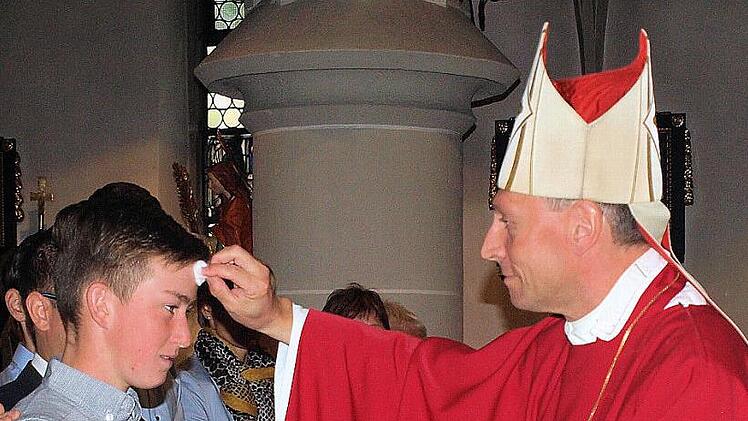 Weihbischof Herwig Gössl spendete in Steinwiesen den Jugendlichen - hier Sebastian Wachter - das Sakrament der Heiligen Firmung. Foto: Susanne Deuerling