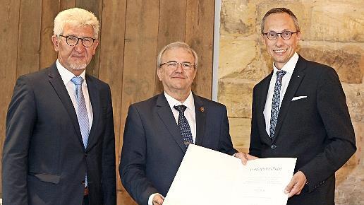 Rainer Lang (M.) wurde im Rahmen seiner Abschiedsfeier mit der Goldenen Ehrennadel des Genossenschaftsverbands Bayern ausgezeichnet; rechts Joachim Hausner, Vorstandsvorsitzender der VR-Bank Bamberg-Forchheim, links Günter Schuster, Aufsichtsratsv...