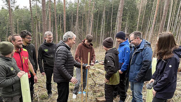 Insgesamt 50 Sch&uuml;lerinnen und Sch&uuml;ler der Maximilian-von-Welsch-Realschule beteiligten sich an einer Baumpflanzaktion des Landkreises und der Waldbesitzervereinigung Kronach-Frankenwald. Das Bild zeigt einen Sch&uuml;ler mit Landrat Klaus L&ouml;ffler beim ...