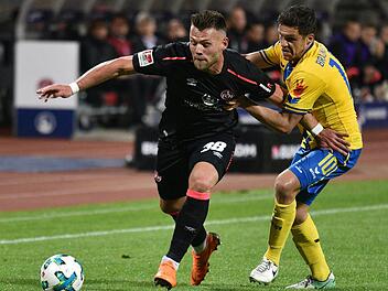 2. Bundesliga, 1. FC N&uuml;rnberg gegen Eintracht Braunschweig, 32. Spieltag im Max-Morlock-Stadion: N&uuml;rnbergs Eduard L&ouml;wen (l) k&auml;mpft mit Braunschweigs Mirko Boland um den Ball. Foto: Nicolas Armer/dpa