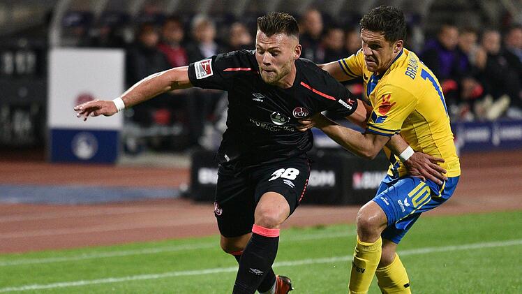 2. Bundesliga, 1. FC Nürnberg gegen Eintracht Braunschweig, 32. Spieltag im Max-Morlock-Stadion: Nürnbergs Eduard Löwen (l) kämpft mit Braunschweigs Mirko Boland um den Ball. Foto: Nicolas Armer/dpa