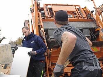 Kai Göppner (r.) und Christian Bayer wuchten die schweren Teile des Sperrmülls in den Abfuhrwagen der Neuseser Firma Wagner. Fotos: Marco Meißner
