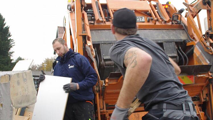 Kai Göppner (r.) und Christian Bayer wuchten die schweren Teile des Sperrmülls in den Abfuhrwagen der Neuseser Firma Wagner. Fotos: Marco Meißner