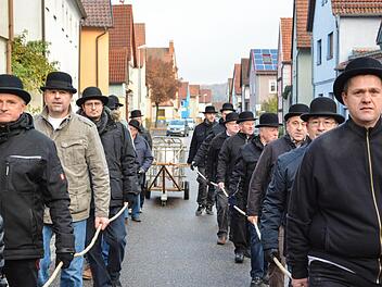 Mit ernster Miene ziehen die Männer der Cocksinnung den Karren mit dem Schwein durch den Ort. Fotos: Björn Hein