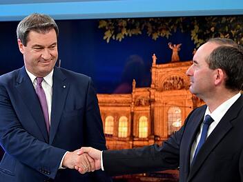Markus Söder (CSU, l), Ministerpräsident von Bayern, gibt Hubert Aiwanger, Spitzenkandidat und Partei-Chef der Freien Wähler in Bayern,  während der Wahl bei einer Fernsehsendung die Hand. Foto: Lukas Barth-Tuttas / Pool/epa/dpa