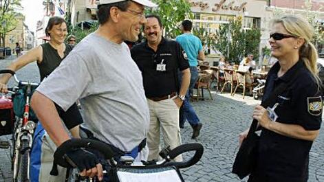 Schnell abgestiegen sind diese Radler, nachdem Karl Pfeiffer und Monika Meyer sie freundlich auf das Fahrverbot am Markt hingewiesen haben. Dann entwickelt sich ein herzliches Gespräch mit den Touristen.