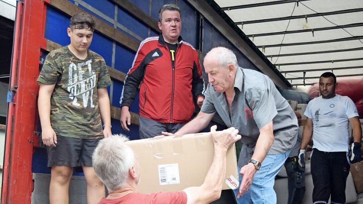 Gemeinsam für rumänische Familien im Einsatz: Viele ehrenamtliche Helfer verstauen die Hilfsgüter mit vereinten Kräften im 22-Tonner-Lastwagen.