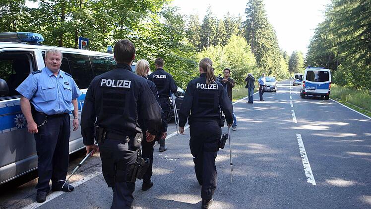 Polizeibeamte mit Suchstöcken gehen auf einer Verbindungsstraße zwischen Rodacherbrunn in Thüringen und Nordhalben in Bayern. Nach dem Fund einer Leiche in einem Waldstück in Thüringen prüfen die Ermittler Verbindungen zum Fall der vor mehr als 15 Jahren verschwundenen Peggy aus Oberfranken. Ein Pilzsammler sei am Samstag auf die Skelettteile gestoßen, teilte die Polizei mit und bestätigte damit einen Bericht des Bayerischen Rundfunks. Der Fundort der Leiche im Saale-Orla-Kreis liegt nur weni...