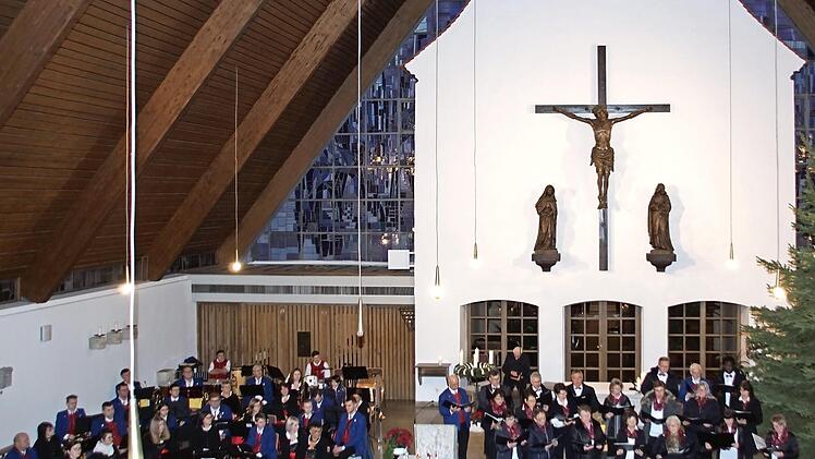 Eine besondere Atmosphäre: Durch die spezielle Verbindung der historischen und der neuen Kirche in Kirchaich wirkt es beim Adventskonzert, als würden Chor und Blaskapelle auf einem Platz vor der Kirche am Christbaum musizieren.  Foto: Sabine Weinbeer