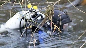 Ein Taucher sucht tiefere Stellen des Flusses ab.