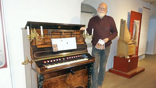 Der Leiter des Ostheimer Orgelbaumuseums&nbsp; J&ouml;rg Schindler-Schwabedissen&nbsp; hat auch f&uuml;r 2020 wieder ein attraktives und abwechslungsreiches Programm zusammen gestellt. Ein Flyer fasst alle H&ouml;hepunkte zusammen. Das Bild zeigt ihn neben dem Walzen-Harmonium aus dem Jahre 1875, das auch den Flyer ziert.  Foto: Marion Eckert