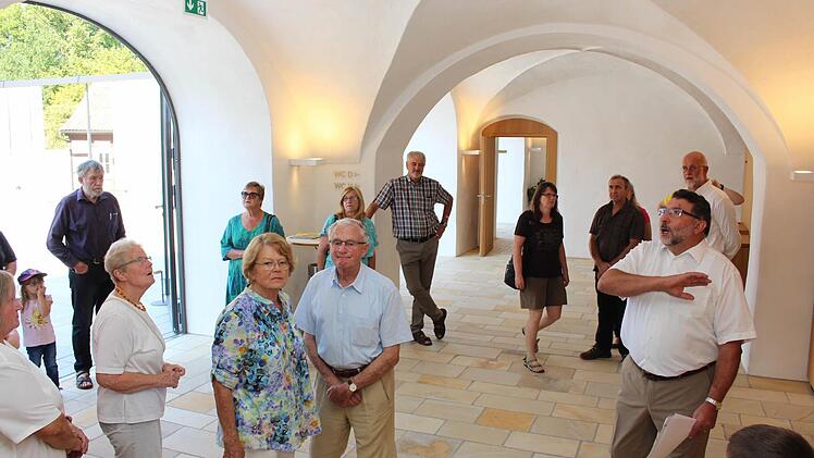 Altbürgermeister Georg Zipfel (rechts) führt die Besucher durch das heutige Foyer, das durch seine Gewölbe eine einmalige Eingangshalle ist. Foto: Evi Seeger
