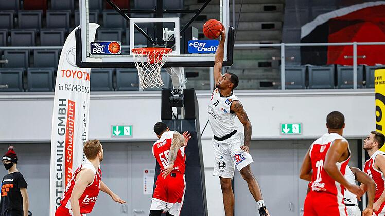 Der Bamberger Aufbauspieler Tyler Larson geht lieber in Deckung, als Isiaha Mike von den Niners Chemnitz den Ball durch den Ring stopft. Foto: Daniel Löb