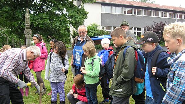 Ein Höhepunkt für die Kinder der 4. Klasse, die zusammen mit den Wildfleckener Feldgeschworenen in den Fluren des Marktes unterwegs waren, das Setzen eines Grenzsteins an der Grundschule. Foto: Manfred Mellenthin