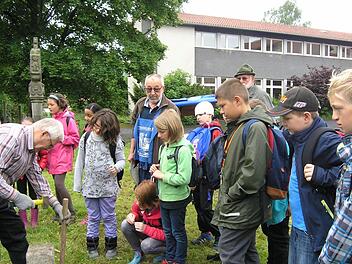 Ein Höhepunkt für die Kinder der 4. Klasse, die zusammen mit den Wildfleckener Feldgeschworenen in den Fluren des Marktes unterwegs waren, das Setzen eines Grenzsteins an der Grundschule. Foto: Manfred Mellenthin