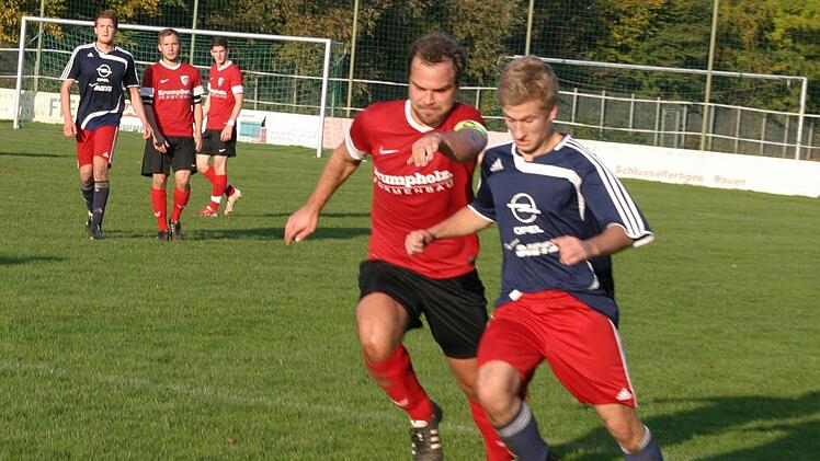 Der wieselflinke Eberner Sven Steinert (rechts, blaues Trikot) zieht mit einem schnellen Antritt an Gästekapitän Schedel vorbei.