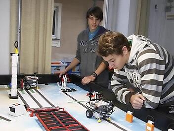 Felix Engelhardt (vorne) und Patrick zahl tüfteln noch. Bis zum Wettbewerb morgen soll der Roboter funktionieren. Fotos: Sonja Adam