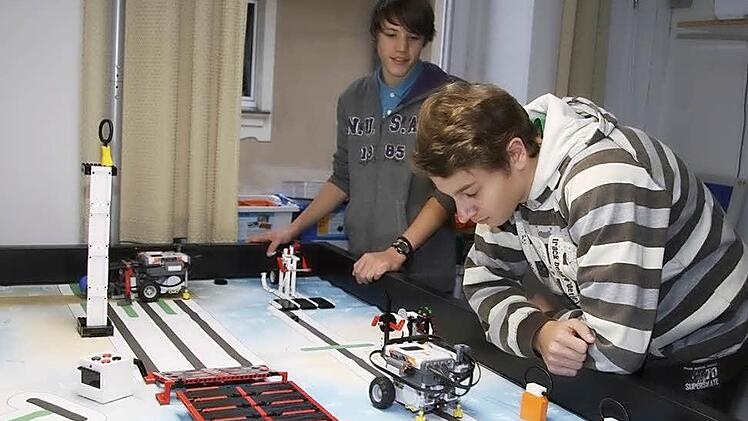 Felix Engelhardt (vorne) und Patrick zahl tüfteln noch. Bis zum Wettbewerb morgen soll der Roboter funktionieren. Fotos: Sonja Adam
