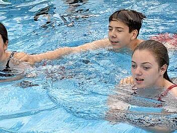 Die drei Jugendlichen Jasmin Prawitz, Ren&eacute; Wiefek und Emma-Jean Roth (von links) zeigten den Besuchern beim anschwimmen im Freibad verschiedene Abschlepptechniken im Wasser. Foto: Uschi Prawitz