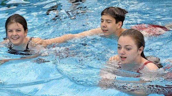 Die drei Jugendlichen Jasmin Prawitz, Ren&eacute; Wiefek und Emma-Jean Roth (von links) zeigten den Besuchern beim anschwimmen im Freibad verschiedene Abschlepptechniken im Wasser. Foto: Uschi Prawitz