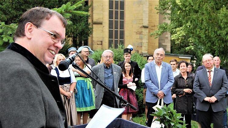 Initiator Gerhard Lehrberger (links) spricht vor den Gästen bei der Enthüllung des Flurl-Denkmals auf dem Kapellenfriedhof. Foto: Sigismund von Dobschütz