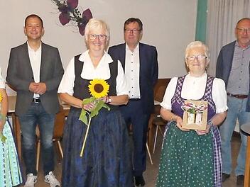 Die Ehrenvorsitzende Marga Eckert (l.) verabschiedet die scheidenden Trachtenbeauftragten mit Naturalien und begrüßt die neuen mit Blumen; dahinter der Bürgermeister und die beiden Vorsitzenden. Foto: Paul Pöhlmann