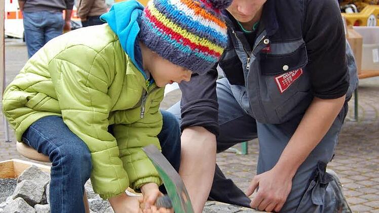 MAncher potentielle Nachwuchs interessiert sich schon früh: Azubi Jannik Nöth zeigt die Kunst des Pflasterns.