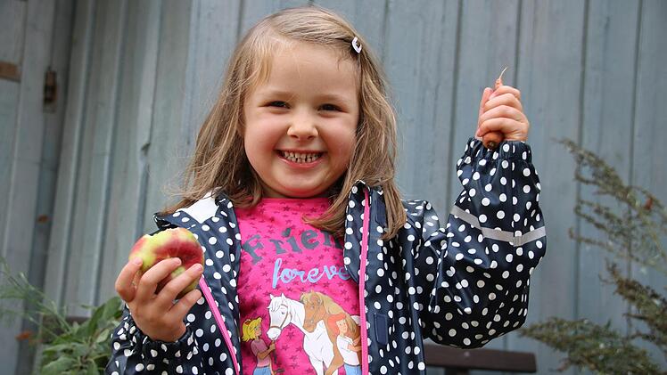 Nora Fine (4) liebt die Gartenarbeit und nascht zwischendurch einen Apfel.